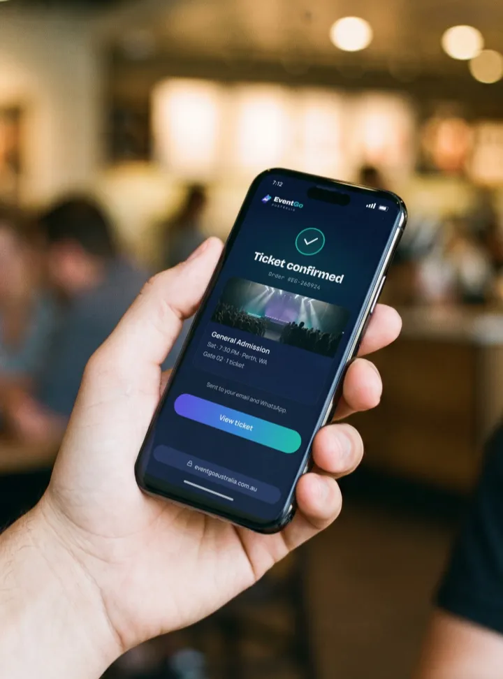 A phone in hand showing a ticket confirmation